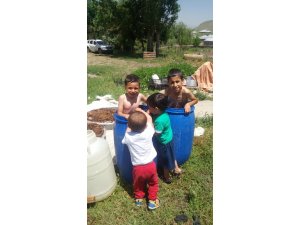 Ağrı’da sıcaktan bunalan çocuklar su dolu varillerde serinliyor