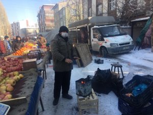 Pazarcılar soğuk havada açık alana kurdukları soba ile ısınıyor