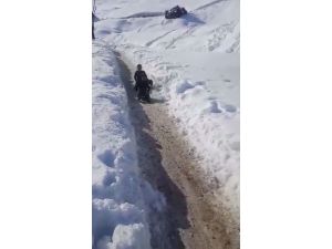 Köylü çocuklar, karla kaplı köy yolunu kayak yoluna çevirdi