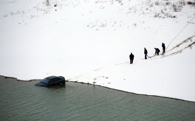 Buzlu yolda kayan otomobil baraja uçtu