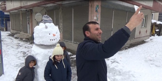 Ailelerin çocukları ile kardan adam selfisi