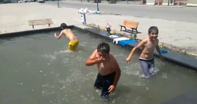 Kars’ta çocuklar süs havuzunda serinledi, vatandaşlar ağaç gölgesine sığındı