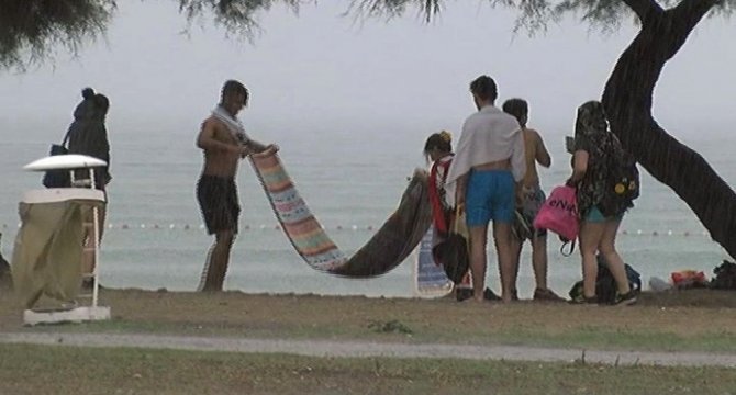 Denize girerken yağmura yakalanan vatandaşlar çocuk parkına sığındı