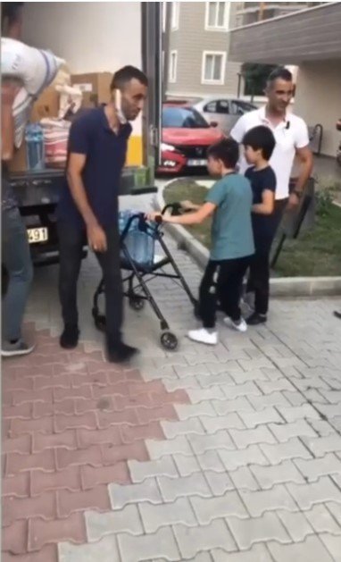 Engelli küçük Muhammet toplanan yardımları yürüteciyle kamyonete taşıdı