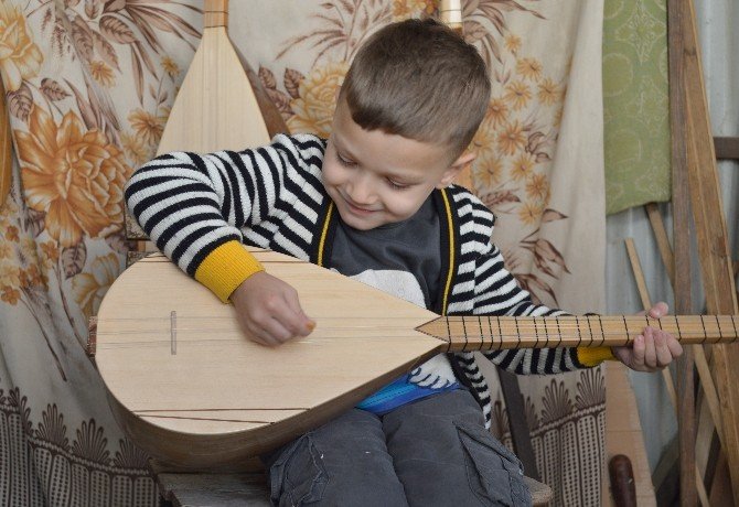 Dede-torun hem saz yapıyor, hem de çalıyor