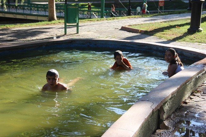 Sıcaktan bunalan çocuklar süs havuzlarında serinliyor
