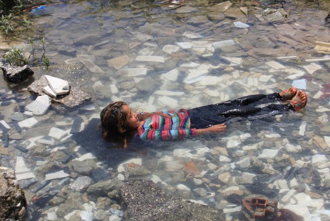 Suriyeli çocuklar pis sularda yıkanıyor