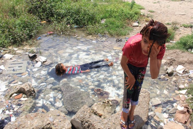 Suriyeli çocuklar pis sularda yıkanıyor